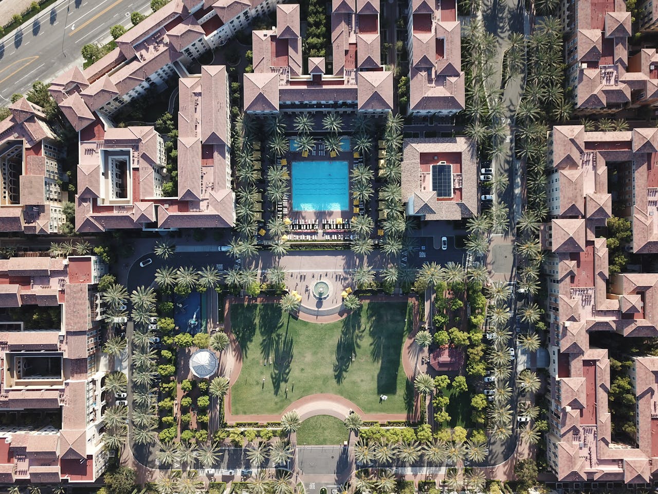 gallery-img-05 Explore an aerial view of a luxurious residential complex featuring a central swimming pool and lush gardens in Irvine, CA.