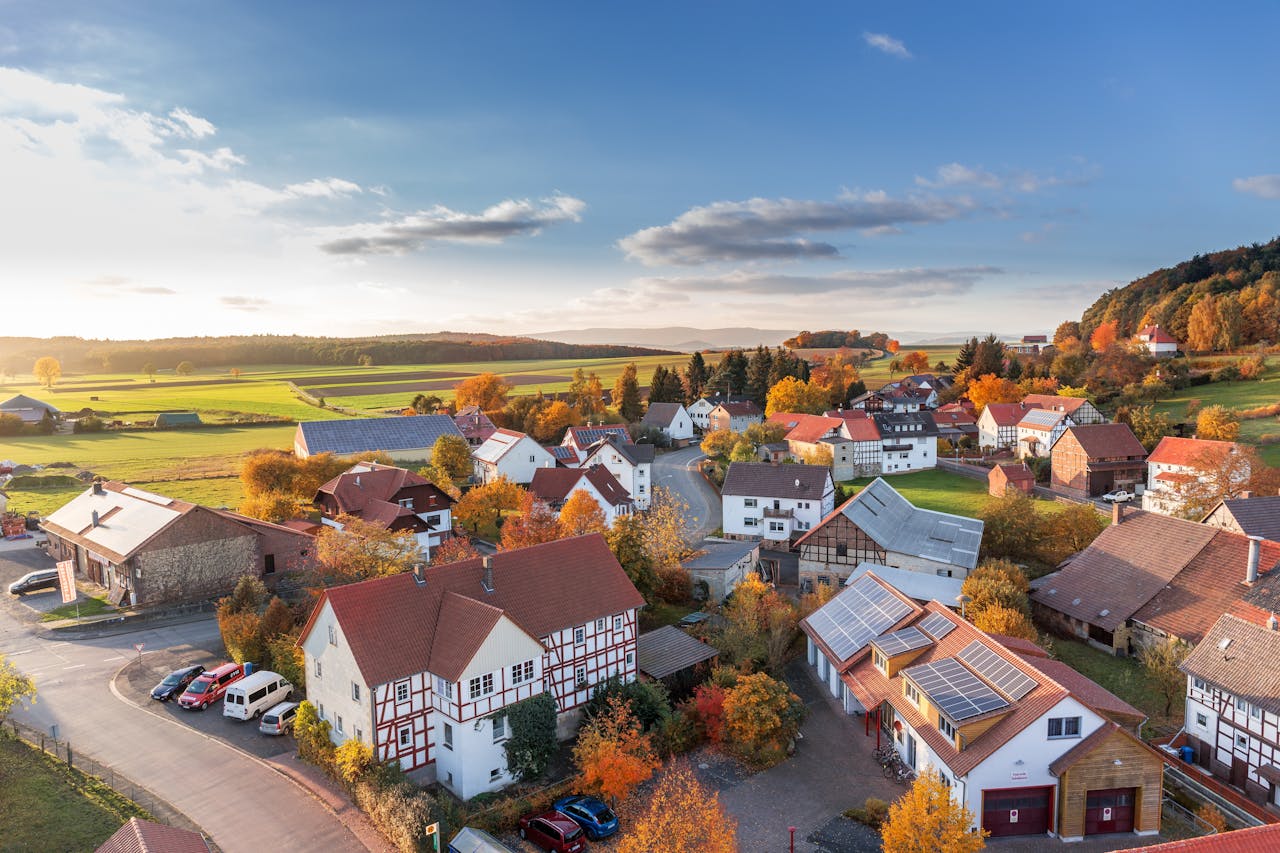 programs-03 Charming aerial view of a rural village in autumn with vivid colors and clear skies.